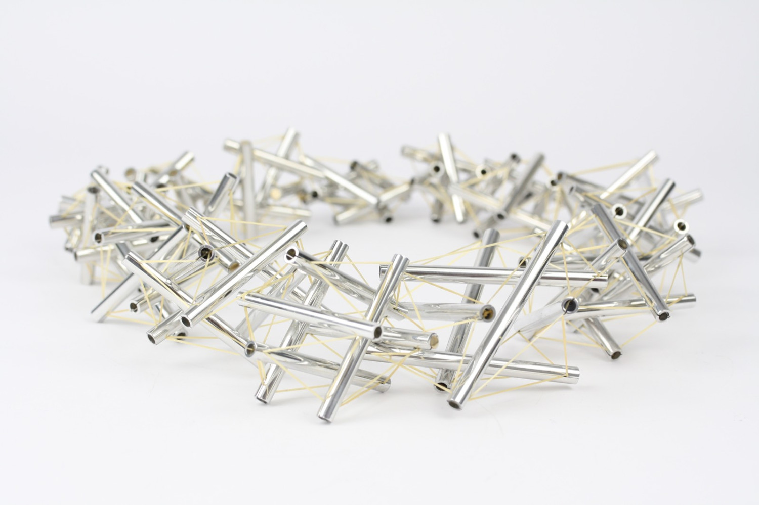 *Tensegrity Neckpiece*, 84 polished aluminium struts, approx. 20m gold .5mm elastic thread