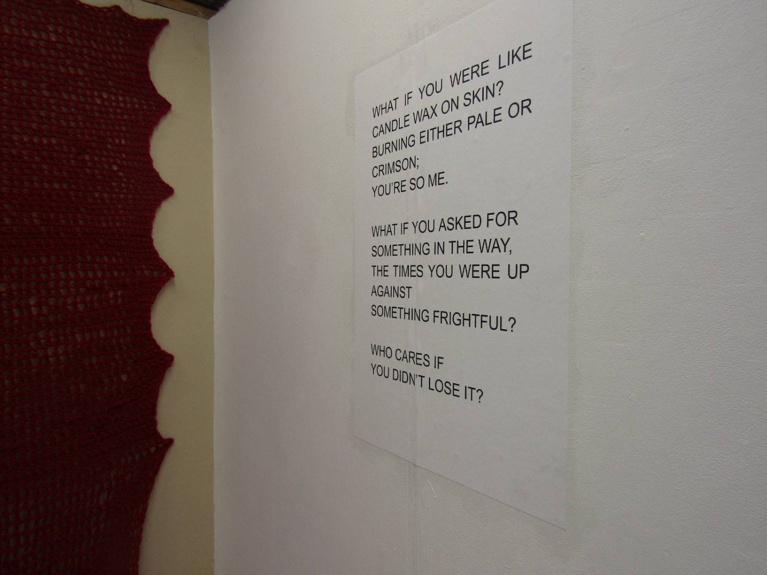 Installation view including crochet work and wallpapered text piece