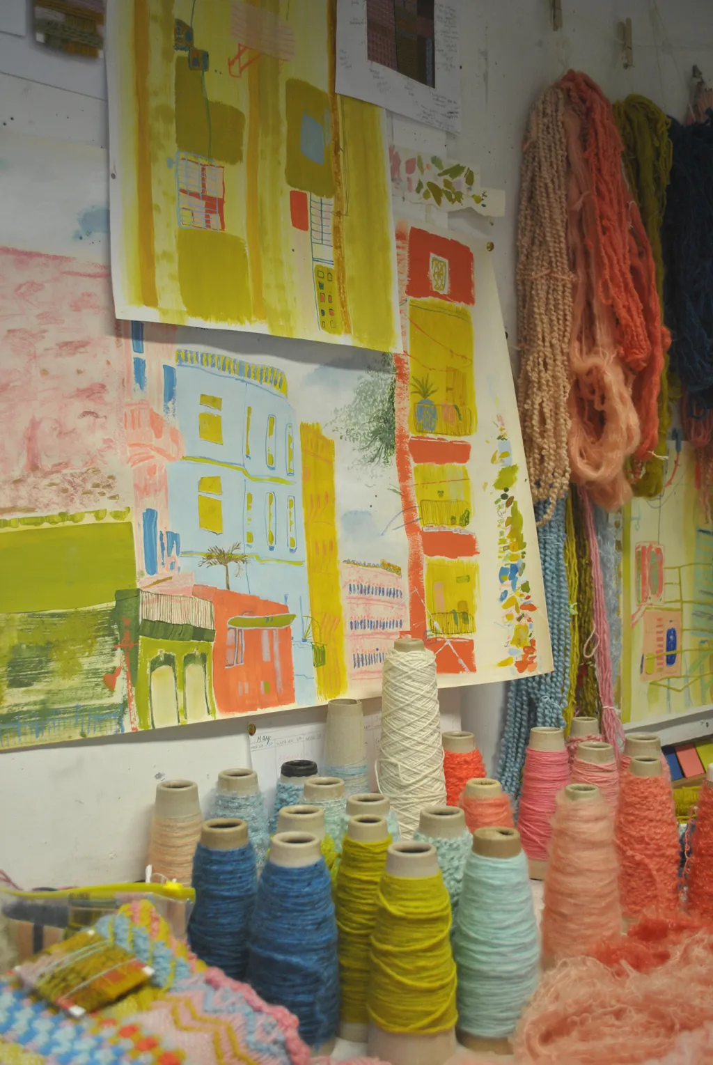 Studio space showing paintings inspired by Cuban architecture, hand dyed yarn spools and hanks