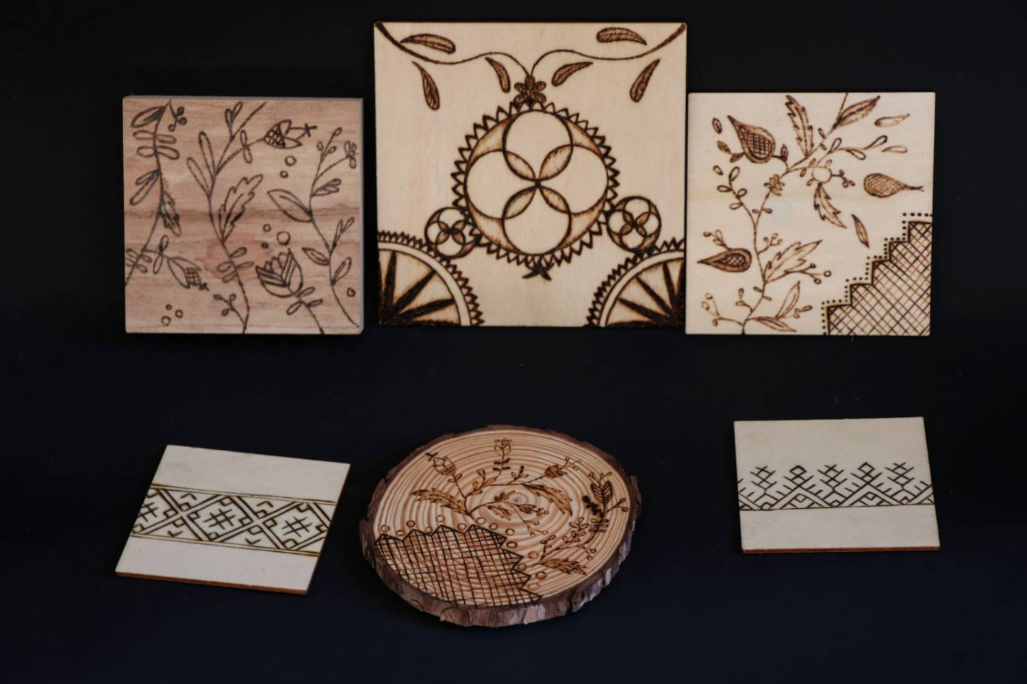 Pyrography pieces exploring traditional embroidery patterns